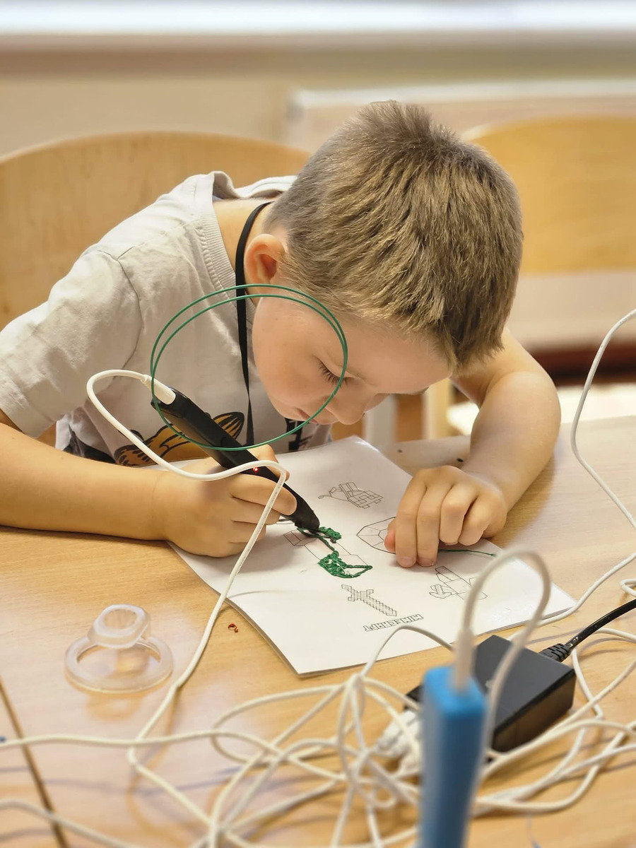 Bērns zīmē ar 3D pildspalvu robotikas nodarbībā